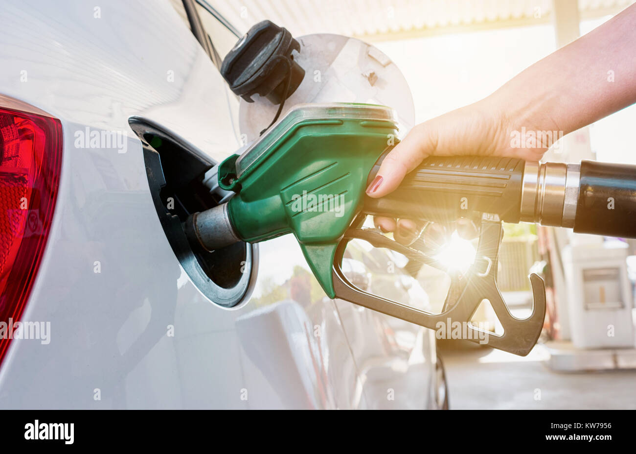 Füllen Sie das Auto mit einer weiblichen Hand auf einer Tankstelle mit Kraftstoff Stockfoto