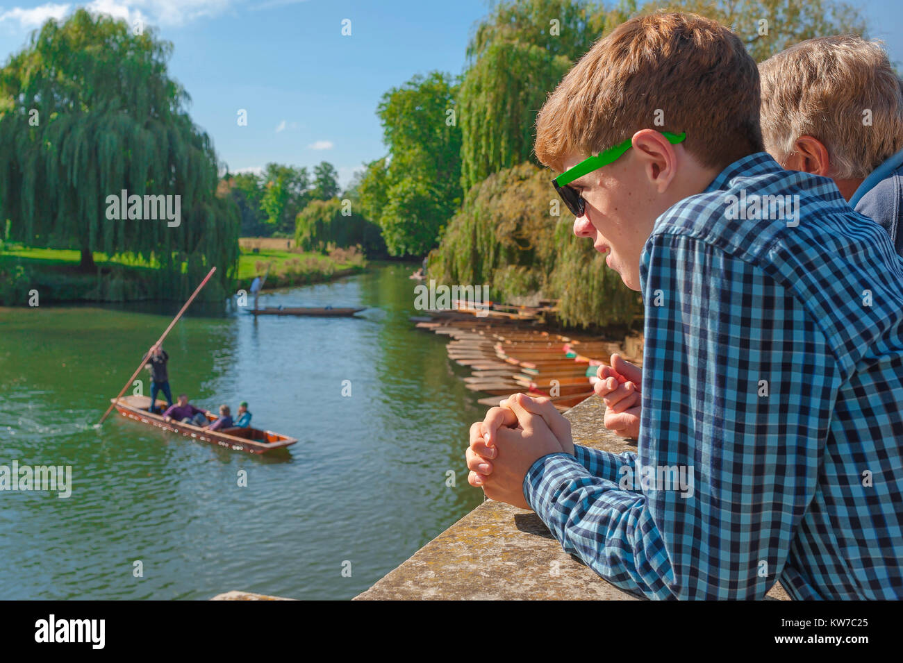 Cambridge UK-Punt, an einem Sommernachmittag beobachtet ein junger Tourist auf der Silver Street Bridge Leute, die auf dem River Cam, Cambridge, England, poken. Stockfoto