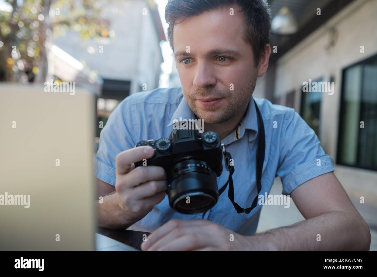 Kaukasischen jungen Mann Fotograf Fotos bearbeiten Sitzen Stockfoto