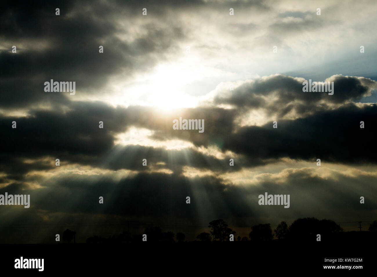 Sonne bricht durch dramatische Wolken in der Dämmerung Stockfoto