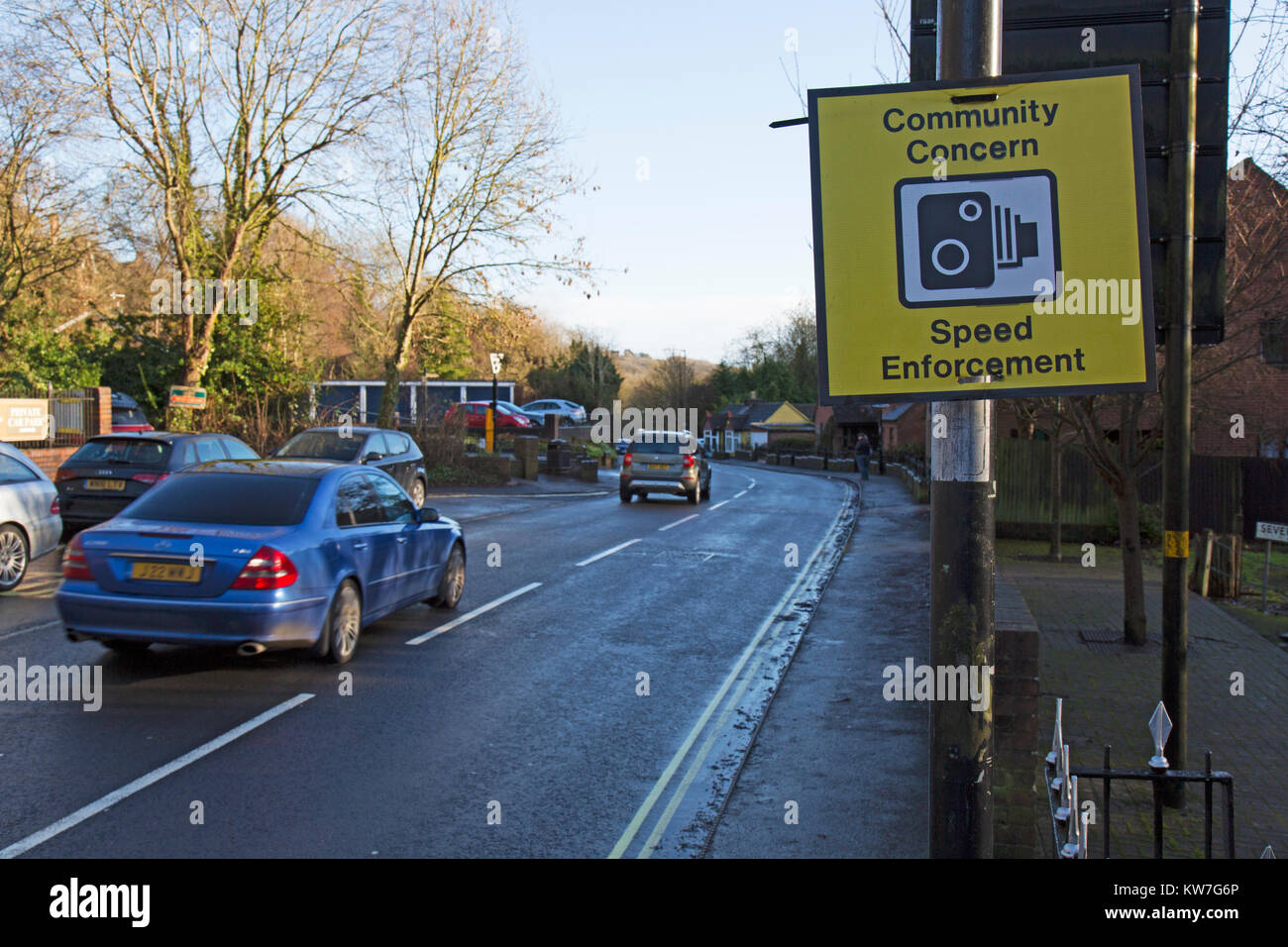 Ein Anliegen der Gemeinschaft zur Durchsetzung von Geschwindigkeitsbegrenzungen kamera Schild an der Seite einer viel befahrenen Straße in England, mit vorbeifahrenden Autos. Stockfoto