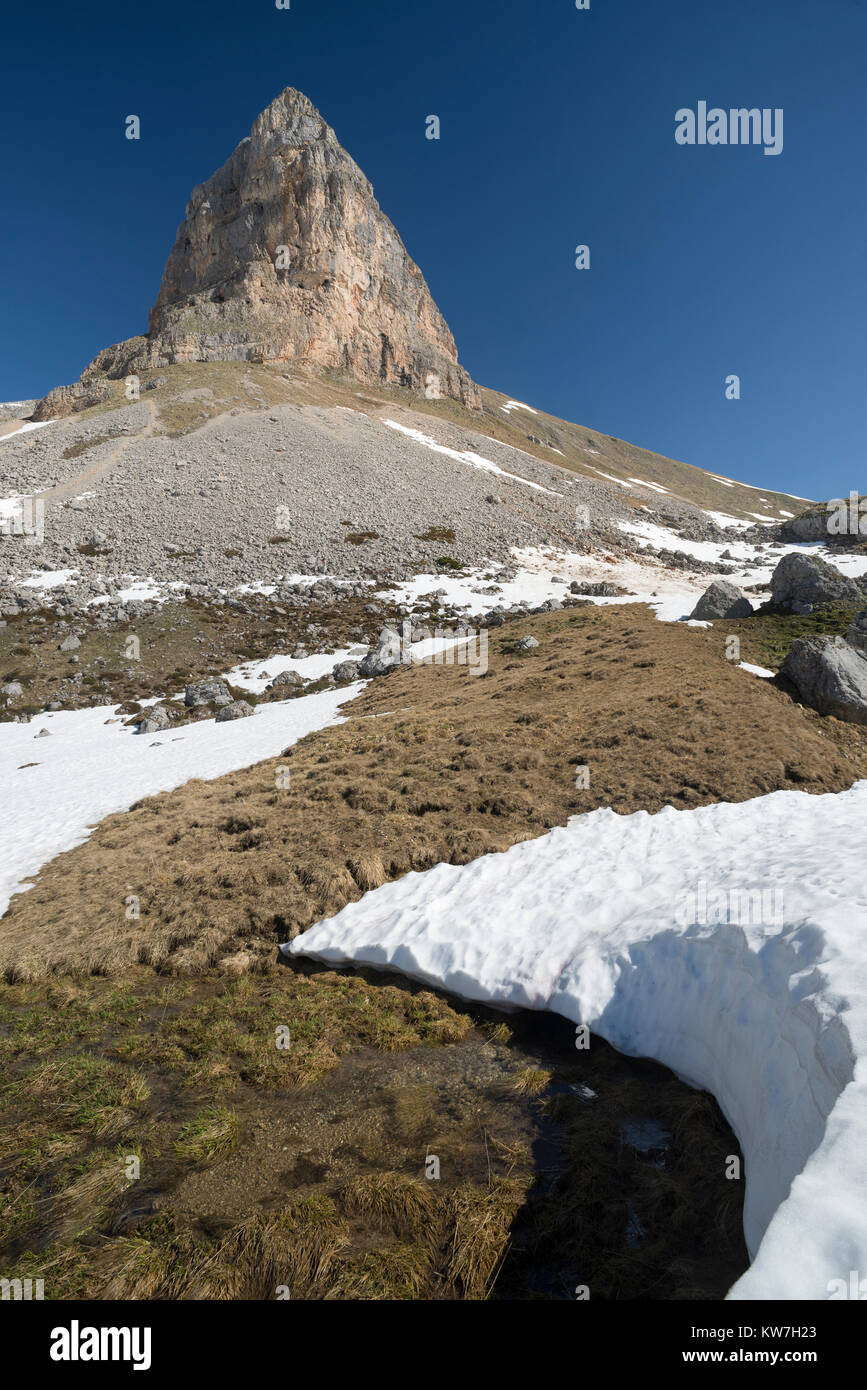 Frühling Schnee schmelzen unter dem steil ansteigende Felsen und Klippen der Roßkopf mit einem Klettersteig im Rofangebirge, Tirol, Österreich Stockfoto
