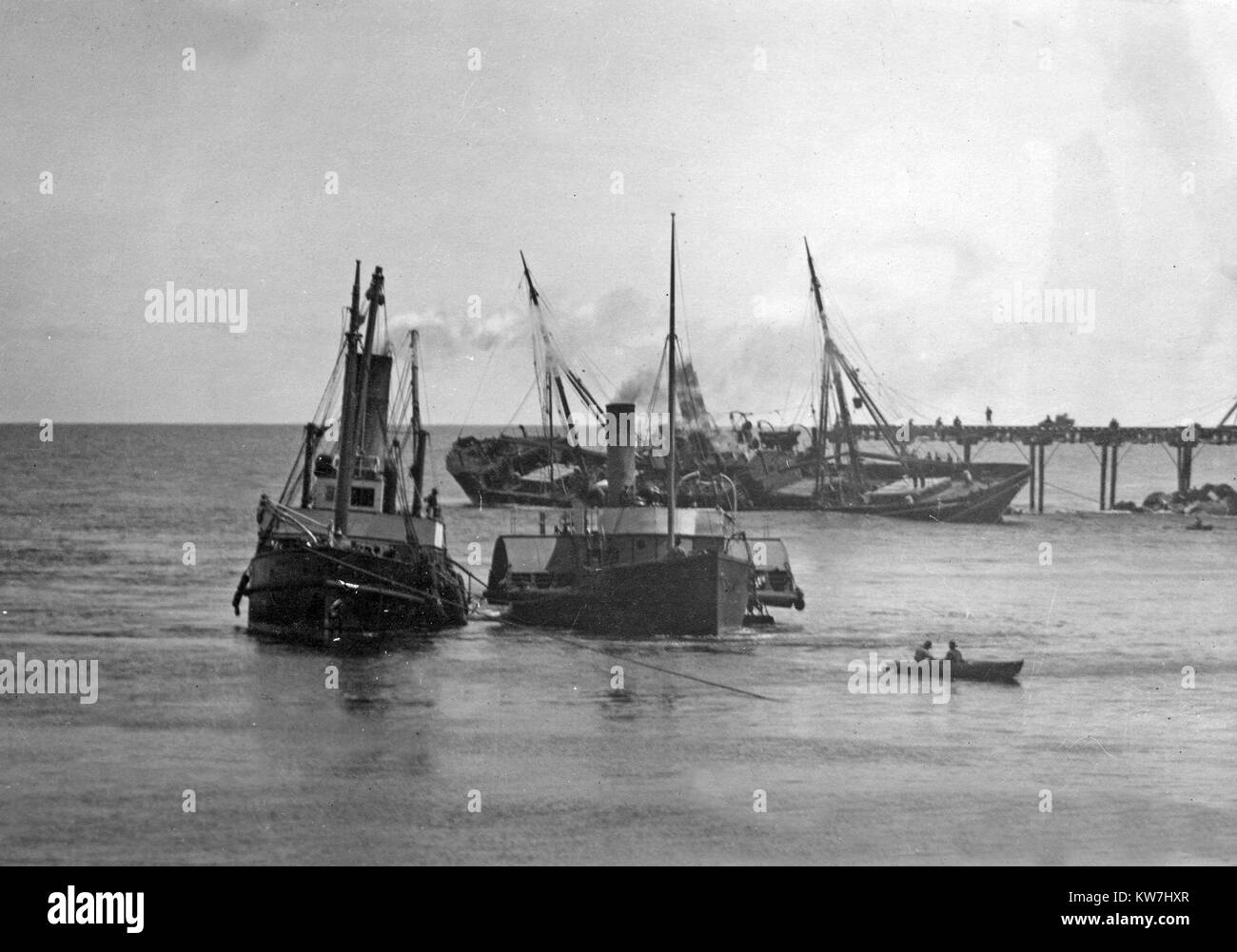 Ein Raddampfer und ein anderes Boot passieren Sie die gestrandeten Hawea, die auf der Nord Tiphead zerstört wurde, während Greymouth verlassen mit 750.000 Fet von Holz, Westland, Neuseeland geladen, am 30.10.1908. Der Stahl Schraube steamship wog 1758 Tonnen brutto und netto Register von 1114 Tonnen. Stockfoto