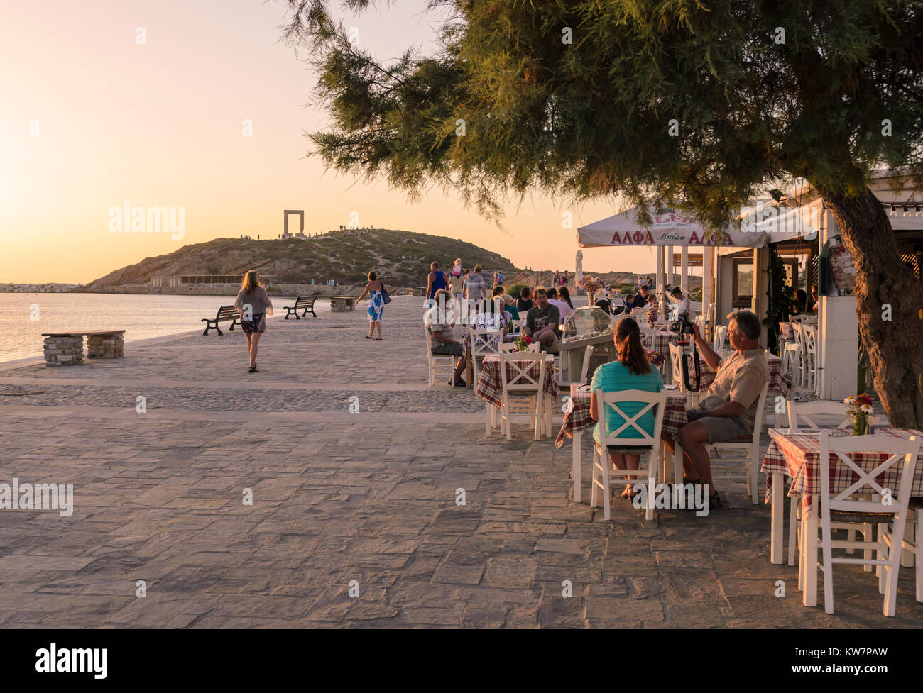 Der belebten Uferpromenade mit Cafes, die zum Tempel des Apollo Arch bei Sonnenuntergang der Insel Naxos, Griechenland Stockfoto