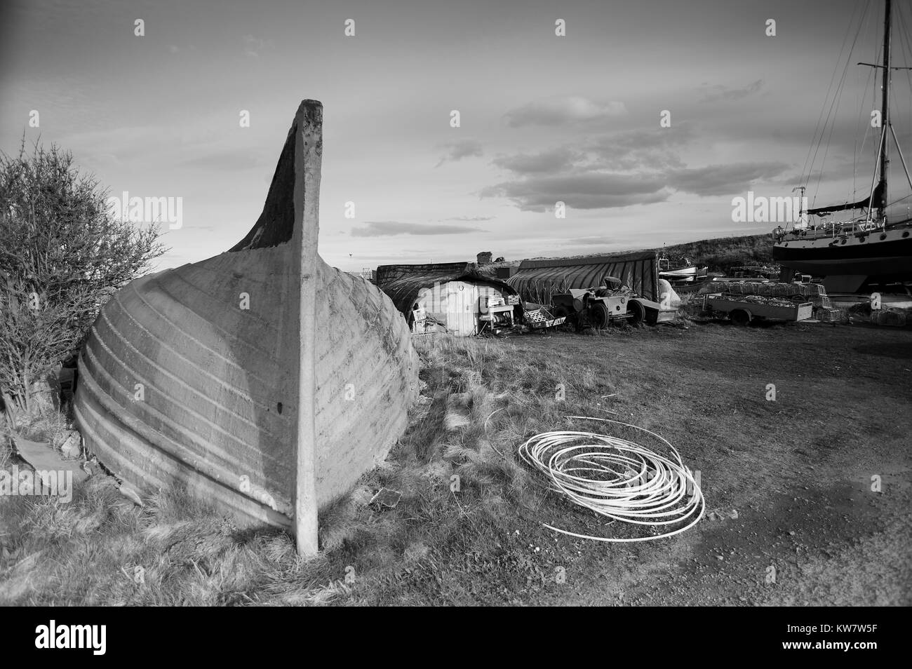 Alte umgedrehten Hering Boote verwendet als Fishermans speichert auf der Insel von Lindisfarne auf dem Northumbrian Küste, UK, GB, England. Stockfoto