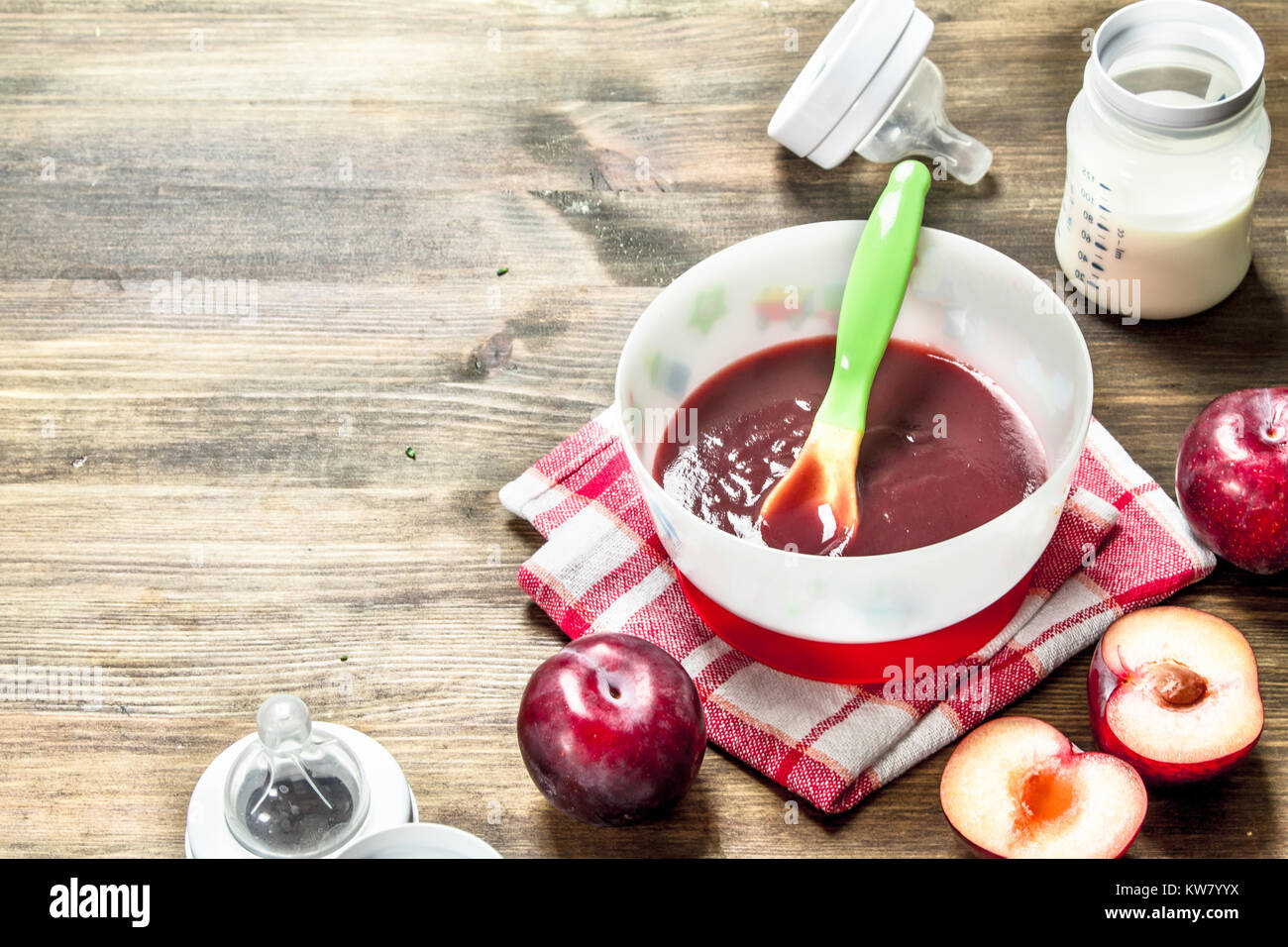 Babynahrung. Püree aus frischen Pflaumen mit Baby Milch in der Flasche ...