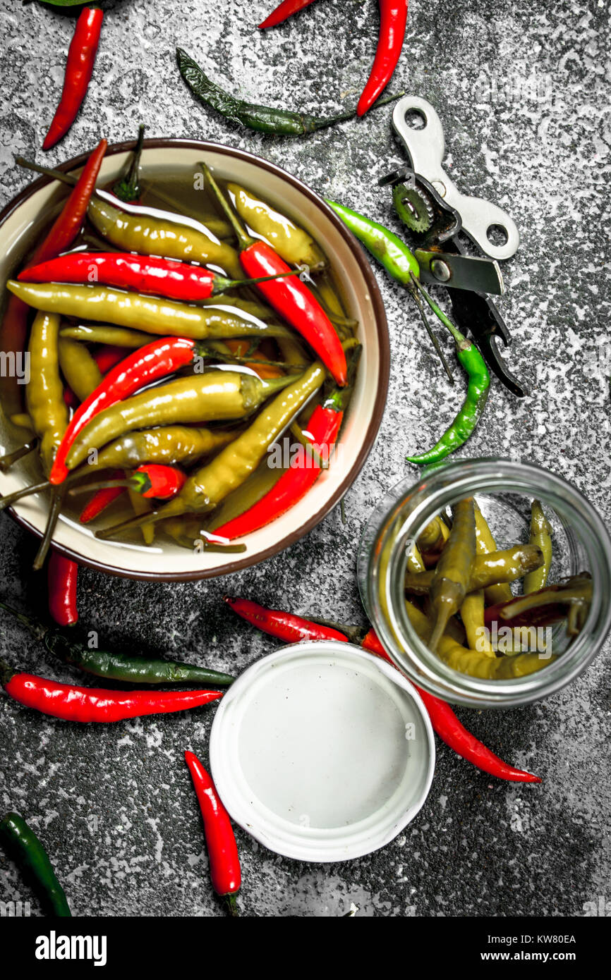 Eingelegte Paprikaschoten in eine Schüssel geben. Auf einem urigen Hintergrund. Stockfoto