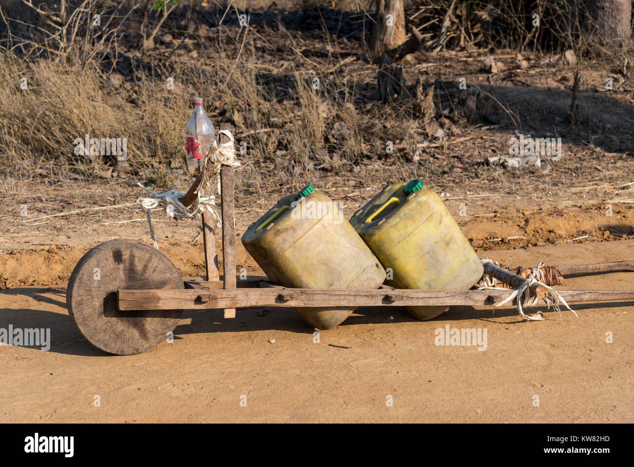 Eine hölzerne Hand Warenkorb mit zwei großen Wasserkrüge, die einheimische verwenden, um knappes Wasser in der trockenen Jahreszeit zu verladen. Morondava. Madagaskar, Afrika. Stockfoto
