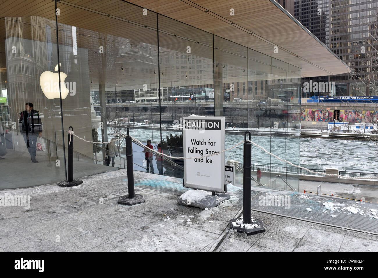 Chicago, USA. 31. Dezember 2017. Schilder Warnung Passanten der fallenden Eis sind auf dem Display rund um das neue Flaggschiff der Apple Store, North Michigan Avenue, in der Nähe des Chicago River. Das Gebäude, das von dem britischen Architekten Foster + Partners, hat ein Dach wie das Cover von einem Apple Laptop geformt und scheint zu fehlen sichtbare Regenrinne. Eiszapfen, die in der aktuellen Sub gebildet haben Null Temperaturen haben der Boden unter Gefährdung der öffentlichen abgestürzt und der Store ist zurzeit mit Blick auf die Kritik von Einheimischen eine Lösung zu entwickeln. Credit: Stephen Chung/Alamy leben Nachrichten Stockfoto