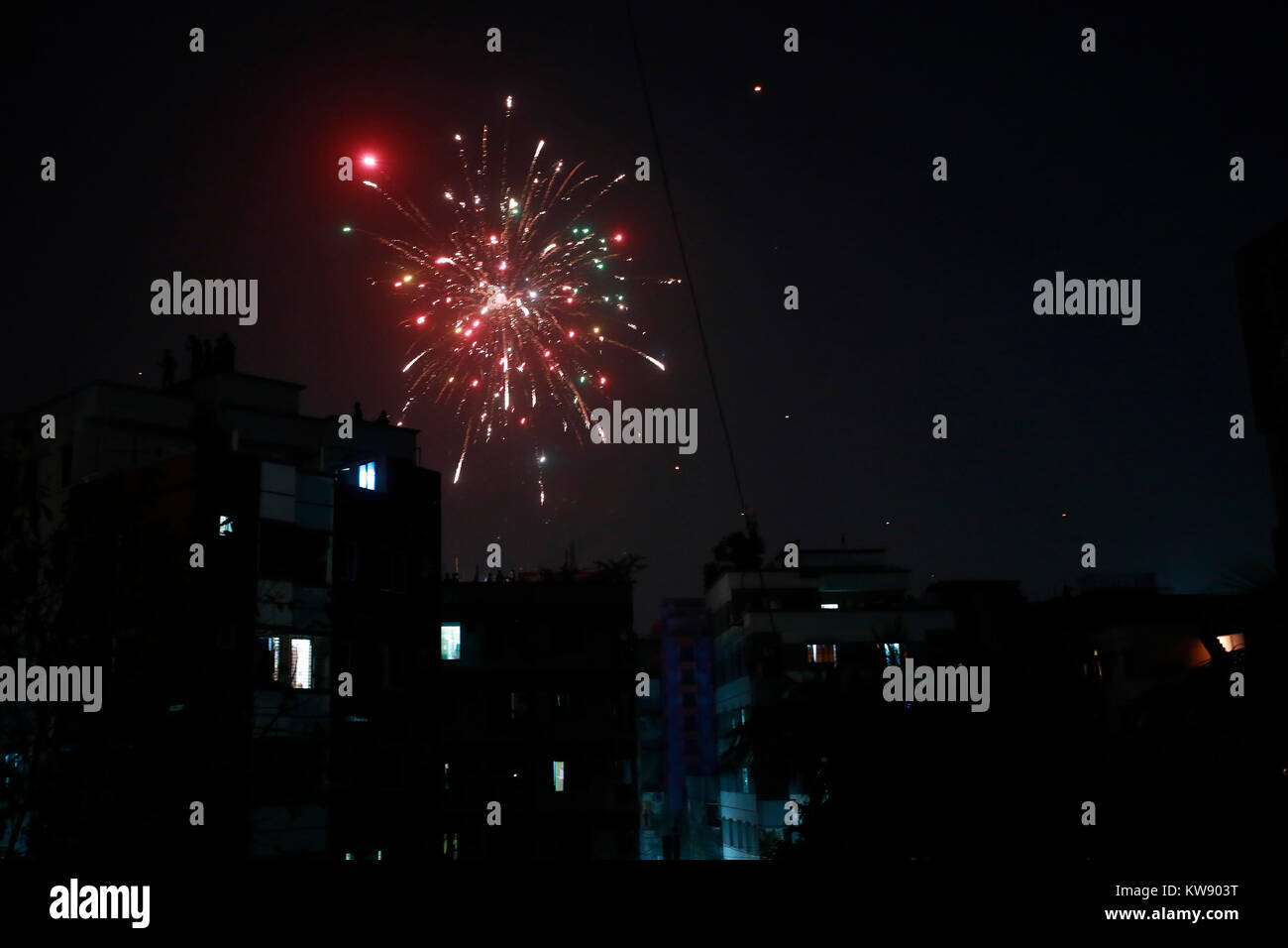 DHAKA, BANGLADESCH - Januar 01, 2017: Feuerwerk den Himmel mit der Luft mit lautem Knallen der Böller gefüllt, so viele auf Dächern versammelten Englisch ins neue Jahr zu feiern, trotz eines Verbots auf Open-air-Programmierer und Parteien, und Feuerwerk. Dhaka, Bangladesch. Stockfoto