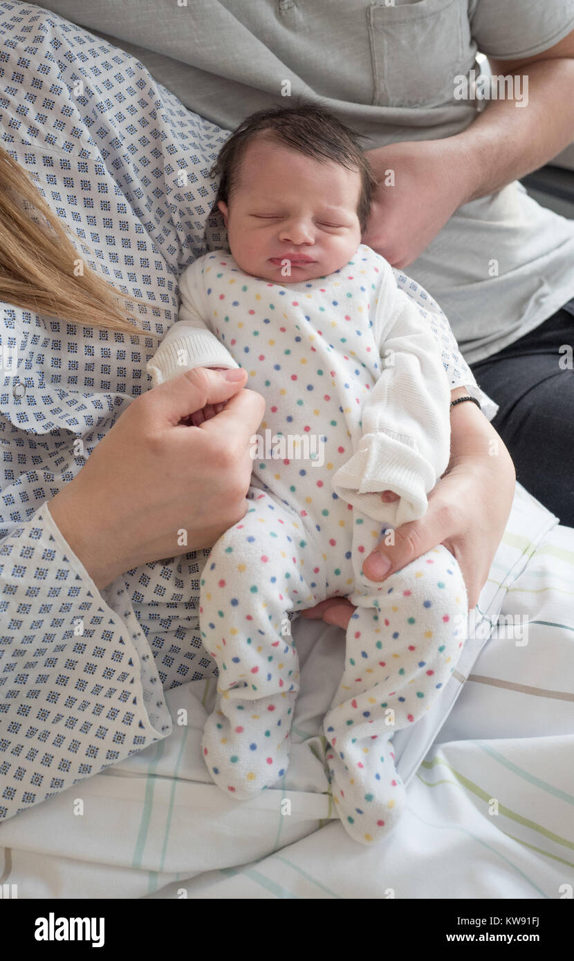 Wenig Filippos hält ein Nickerchen in den Armen seiner Mutter Konstantina und sein Vater Vyron in der Charité Campus Berlin, Deutschland, 01. Januar 2018. Filippo wurde um 00:08 geboren bin, ist das erste Kind des Jahres in Berlin. Foto: Jörg Carstensen/dpa Stockfoto