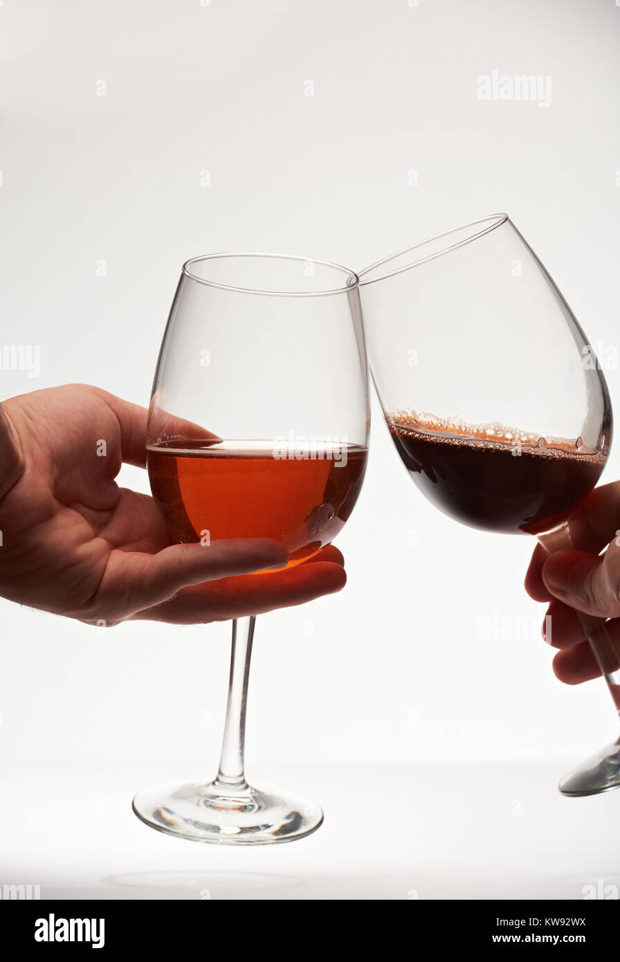 Zwei Weingläser cheers Close-up auf weißem Hintergrund. Toast mit Rotwein Stockfoto
