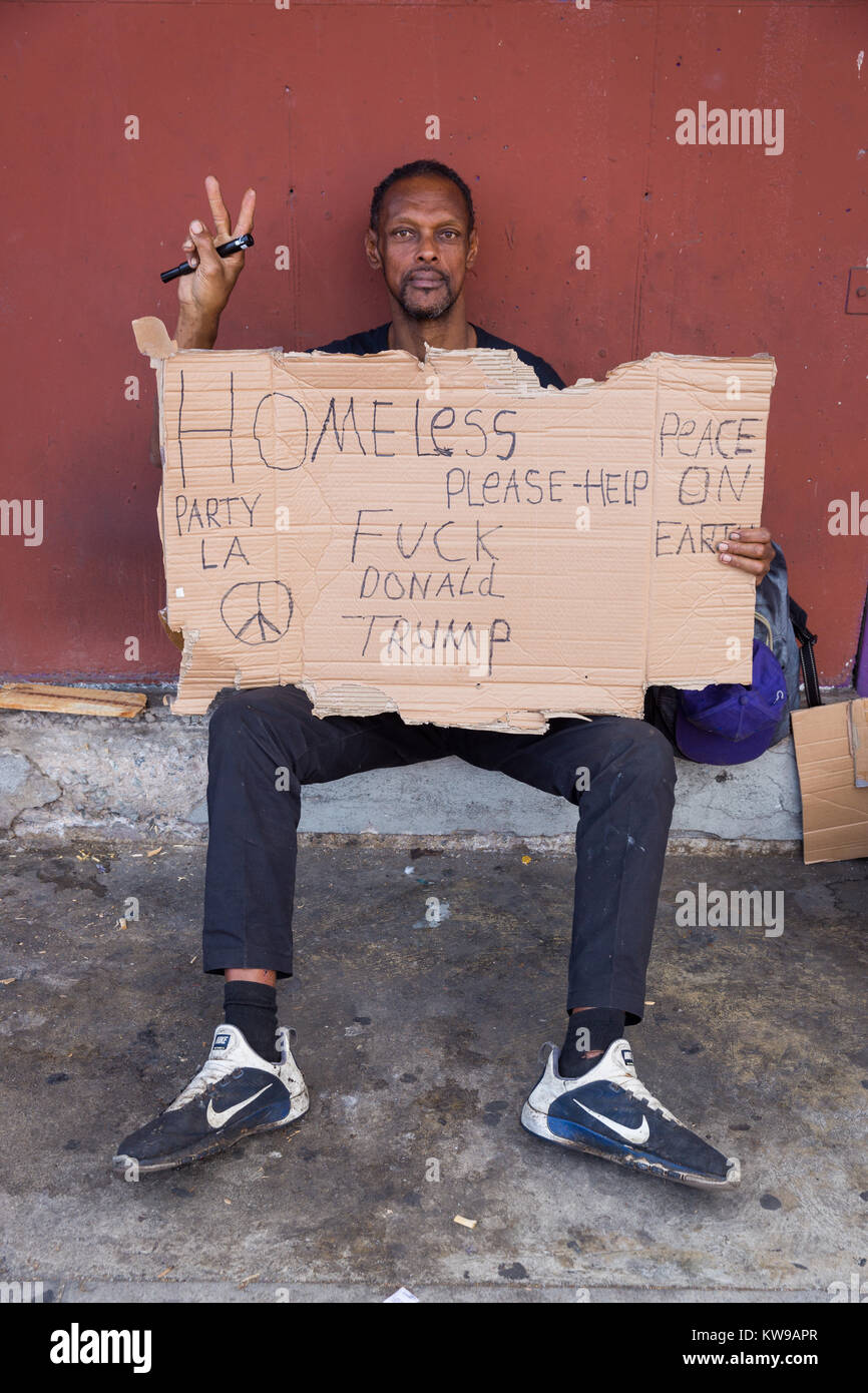 Obdachloser mit Vorzeichen um Hilfe zu bitten und zu kritisieren Präsident Trumpf. Stockfoto