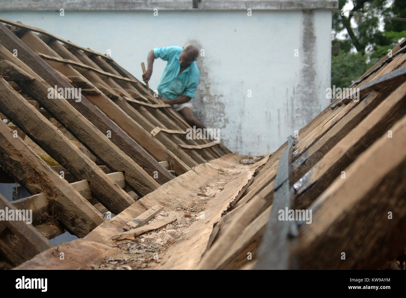 Tischler Arbeiten auf dem Dach der Schule, Tamil Nadu, Südindien. Die Balken sind von Holz aus der Palmyra palm gemacht. Stockfoto