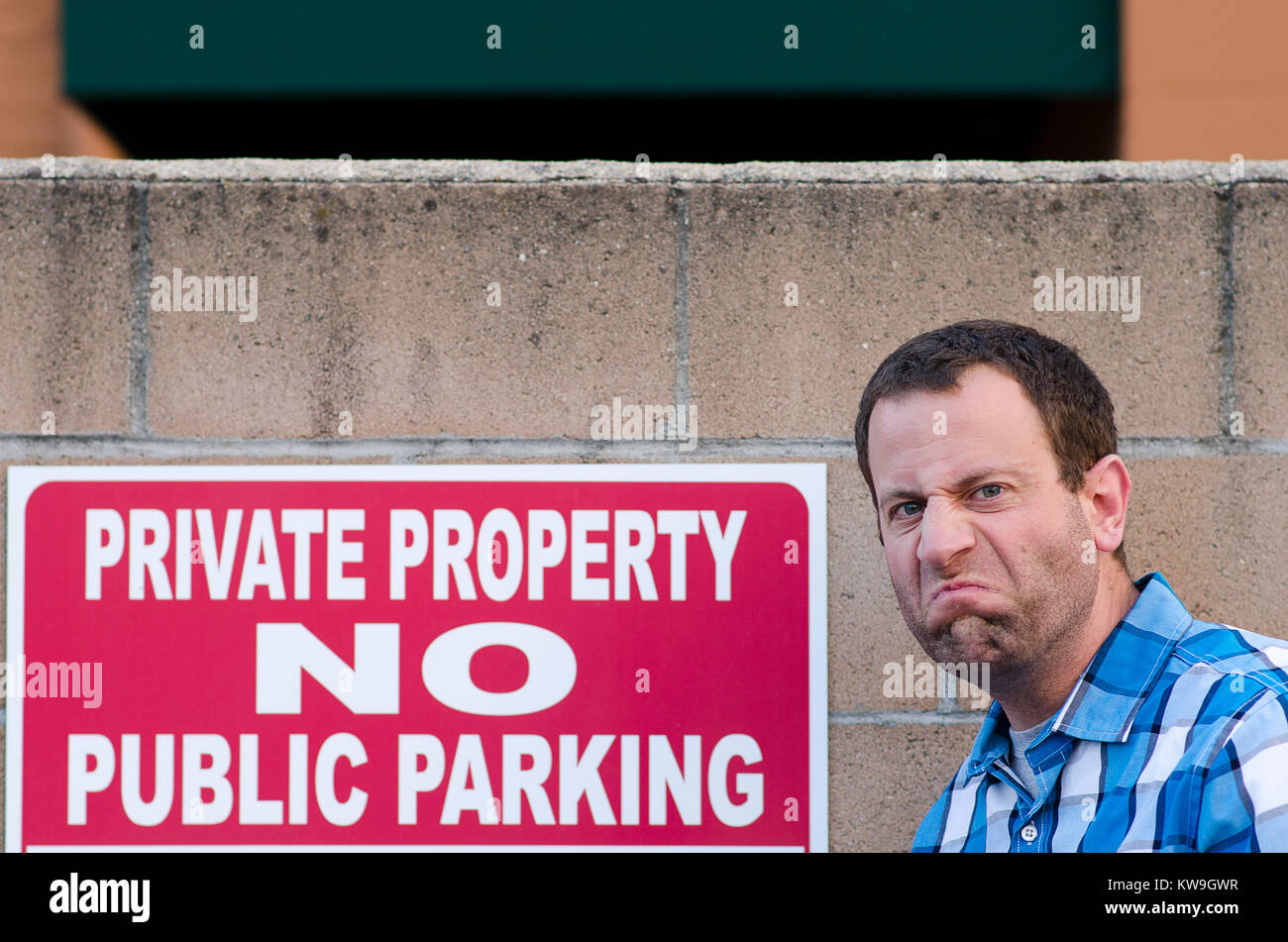 Verärgert Mann in der Nähe von einem Parkplatz Schild Stockfoto