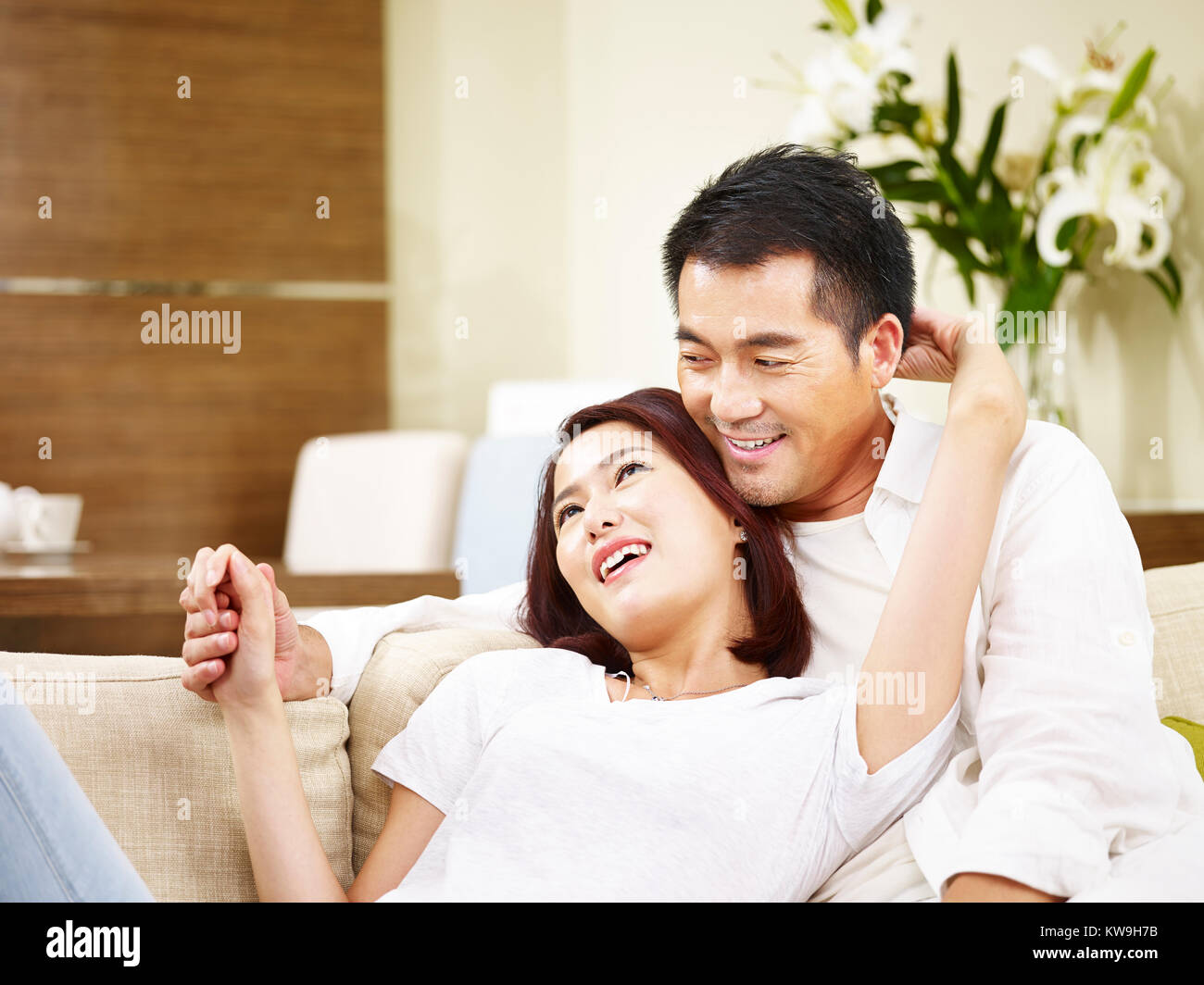 Asiatische Paar auf Familie Couch zu Hause sitzen sprechen. Stockfoto