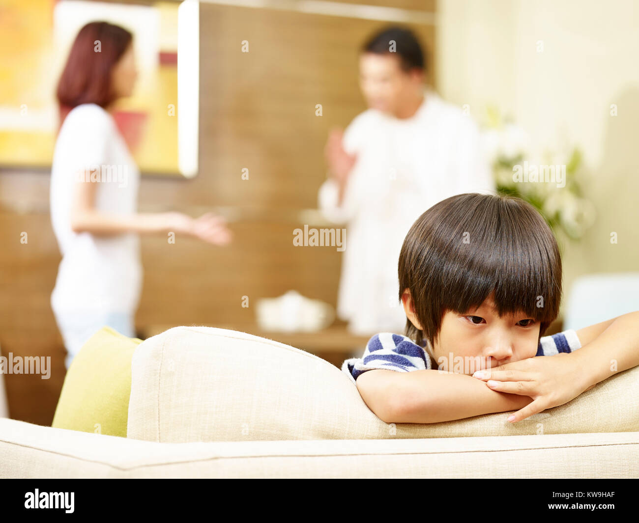 Asiatische Kind scheint traurig und unglücklich, während sich die Eltern streiten im Hintergrund. Stockfoto