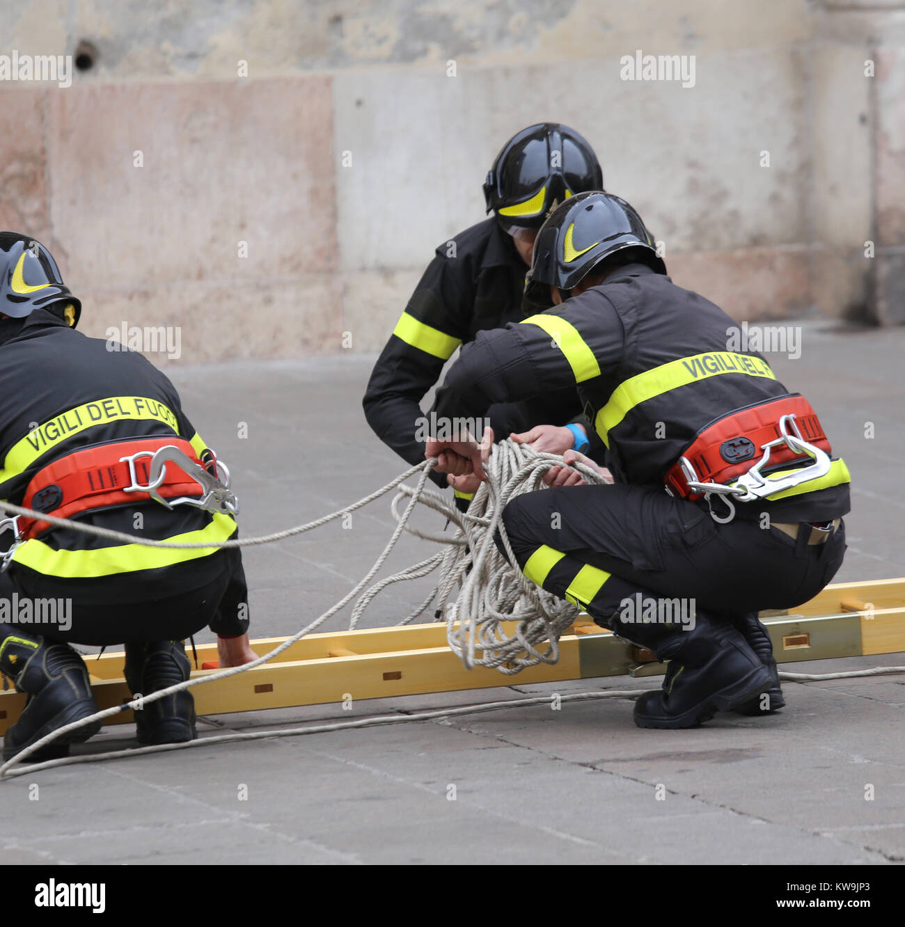 Vicenza, Italien - Dezember 4, 2015: drei Feuerwehrmänner während und Praxis Übung mit langen Leiter aus Holz Stockfoto