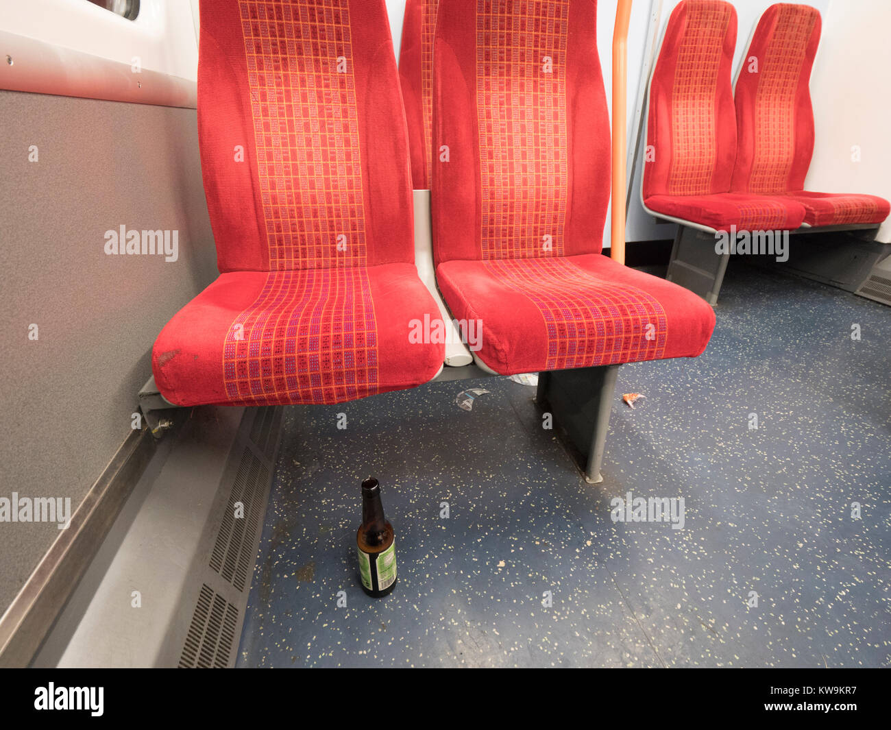 Die Sitze in der S-Bahn Wagen mit einer Flasche Bier auf dem Boden Stockfoto