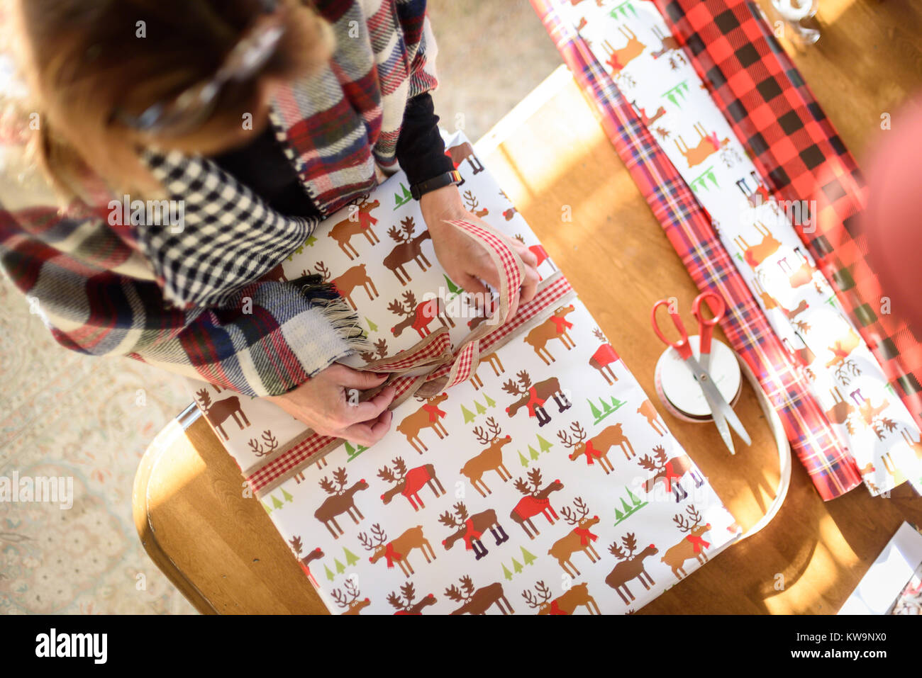 Ansicht von oben von Frau Verpackung Weihnachtsgeschenke am Tisch an einem sonnigen Tag Stockfoto
