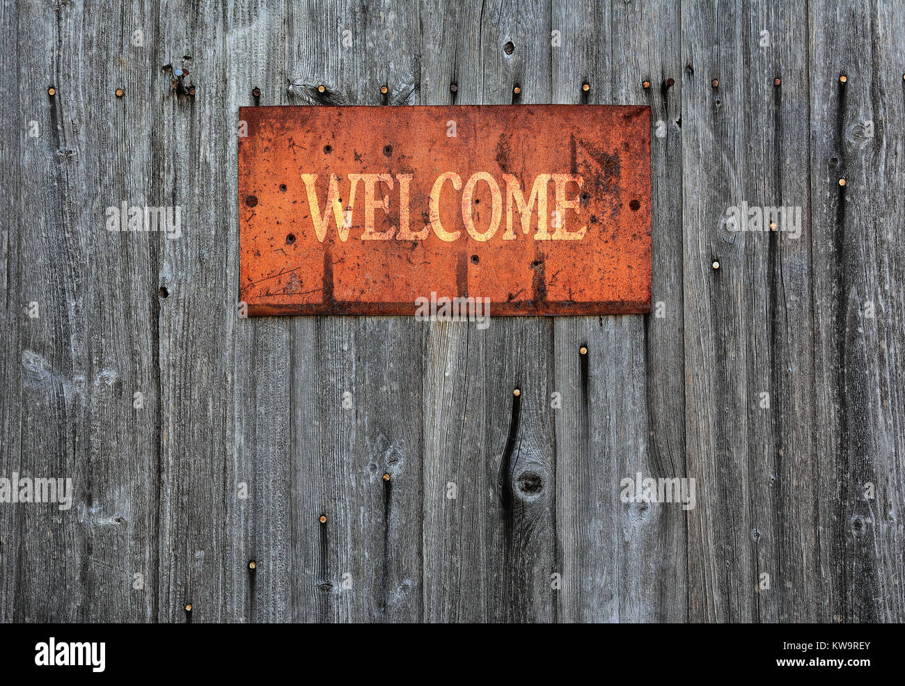 Rostiges Metall Schild an die Holzwand mit dem Wort Willkommen. Stockfoto