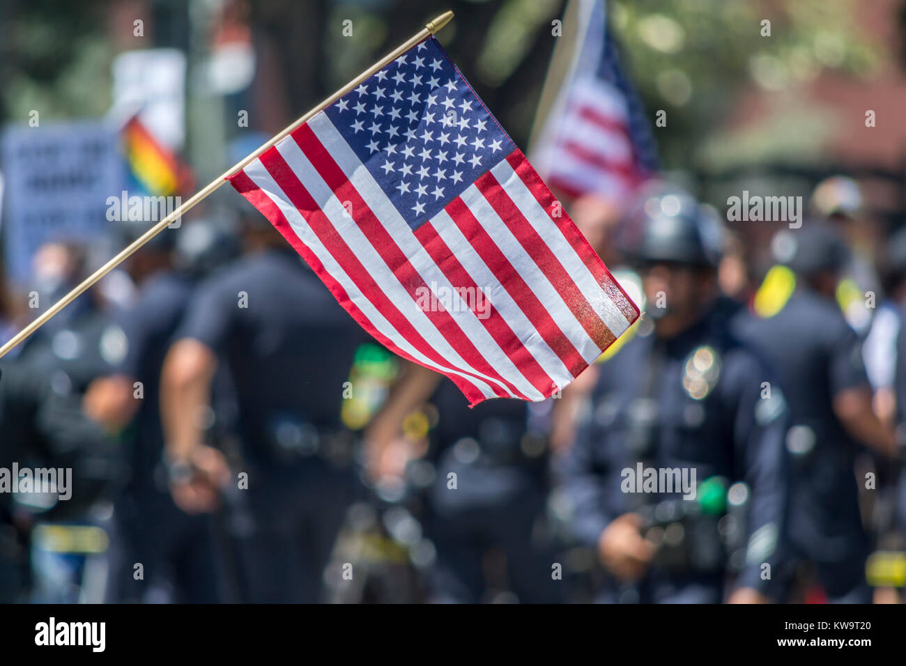 Amerikanische Flagge auf einer Kundgebung mit der Polizei im Hintergrund, Stockfoto
