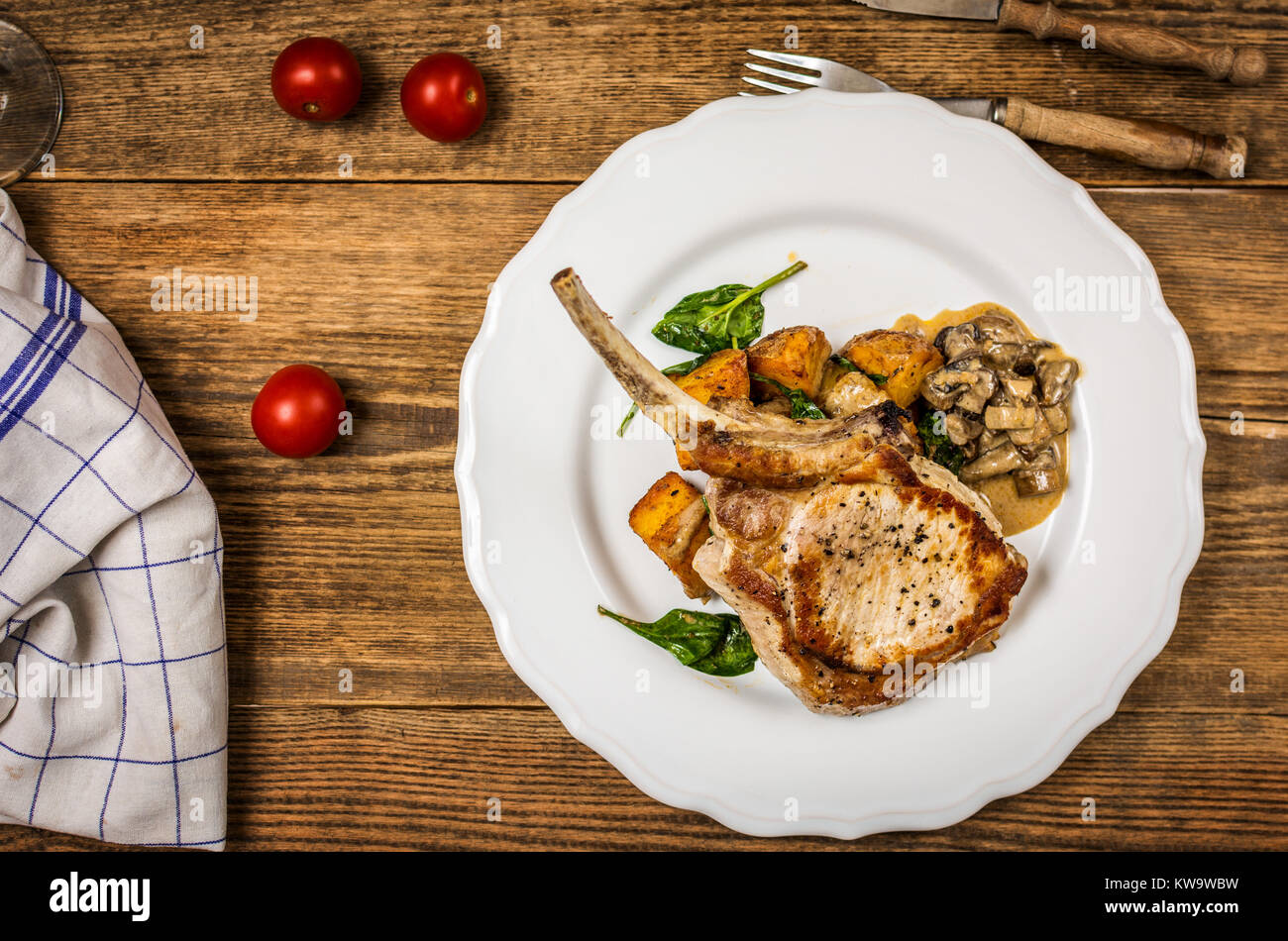 Gebackene Schnitzel oder Kotelett mit Pilzsauce und Kartoffeln mit Spinat Top View Stockfoto