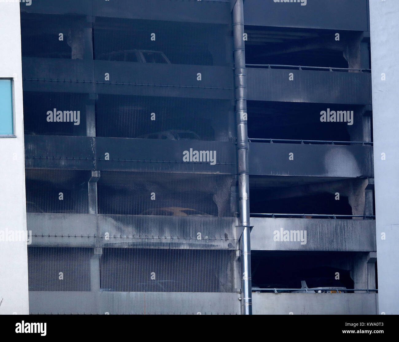 Der ausgebrannte Tanks der Autos an mehrstöckiges Parkhaus in der Nähe der Echo Arena in Liverpool gesehen werden, nach der letzten Nacht Brand, Hunderte von Autos zerstört. Stockfoto