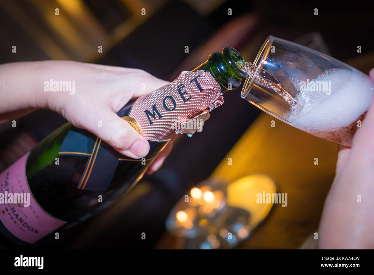 Gießen rosa Champagner aus einer Flasche Moet und Chandon ein Ereignis zu feiern. Stockfoto
