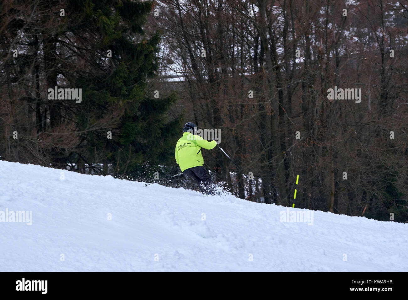 WINTERBERG, Deutschland - 16. FEBRUAR 2017: der Mann, der in fluoreszierende Jacke ein Schwingen auf einer Piste am Skikarussell Winterberg Stockfoto