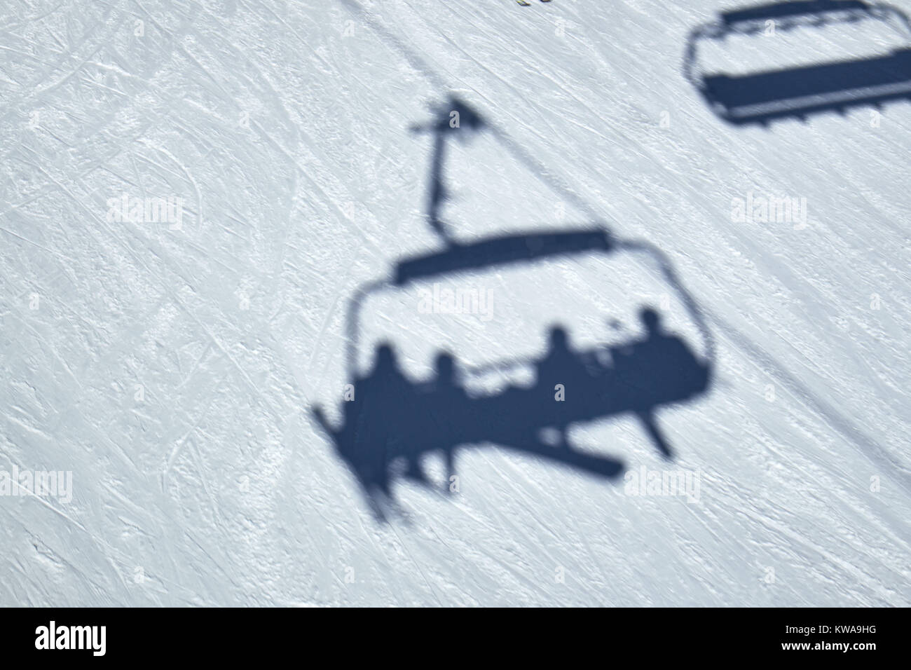 Schatten einer Sesselbahn gleiten über den Schnee auf dem Boden in Skikarussell Winterberg Stockfoto