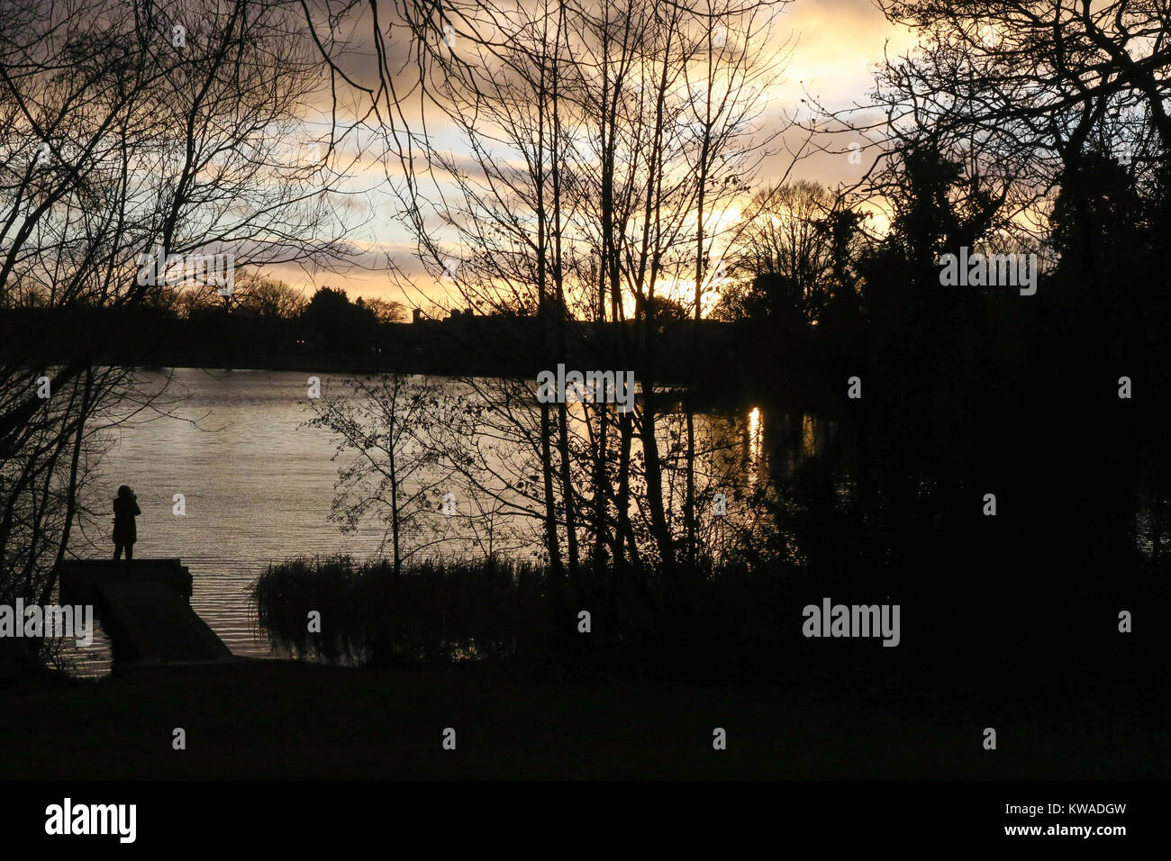 Lurgan, Nordirland. 01. Januar 2018. UK Wetter - ein gemischter Tag mit Sonnenschein und Duschen mit kaltem Wind. Person takiing Foto von winter Sonnenuntergang am Telefon. Quelle: David Hunter/Alamy leben Nachrichten Stockfoto