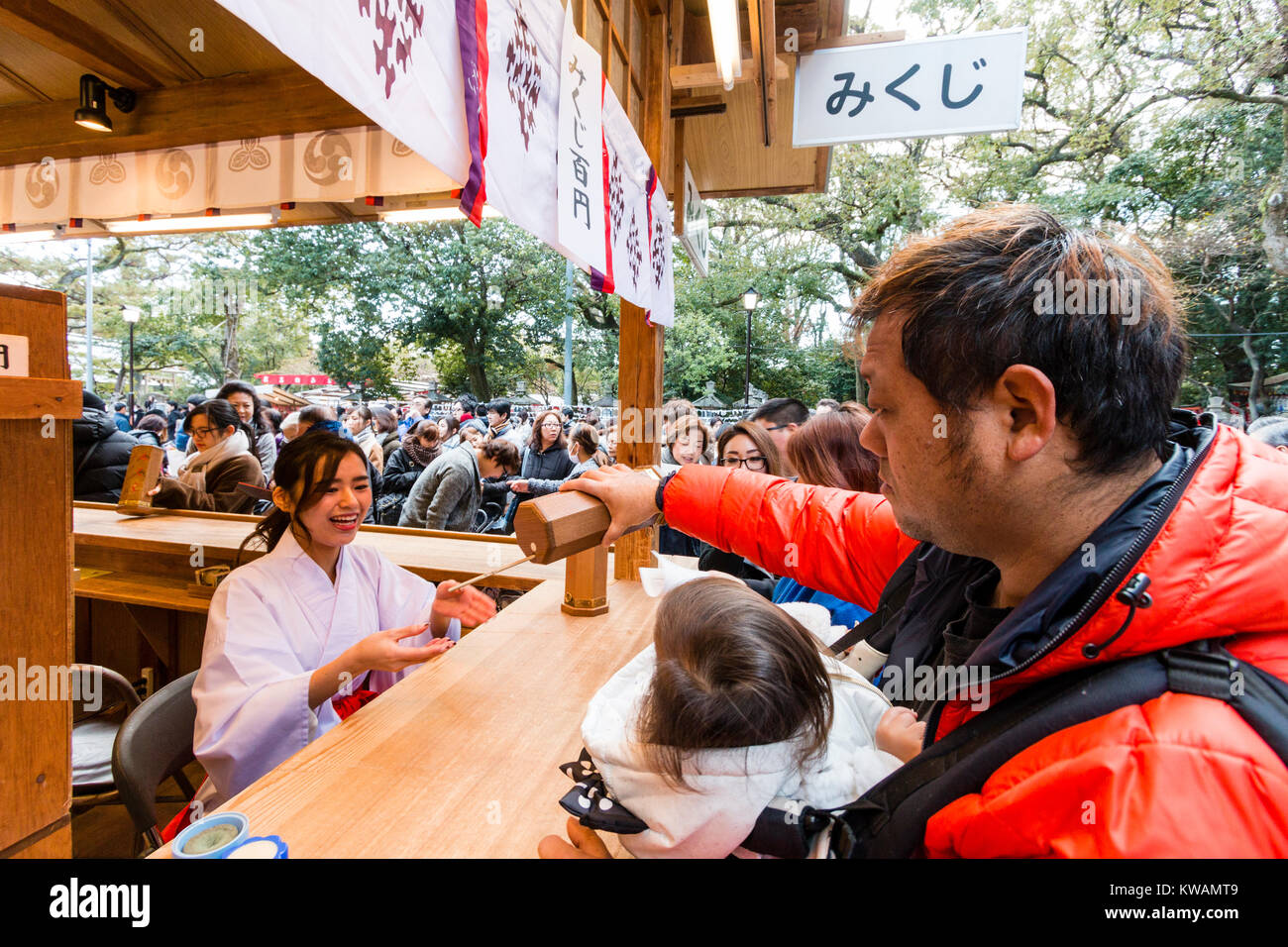 Japan, Nishinomiya, Heiligtum. Für das neue Jahr. Menschen kaufen omikuji, Papier fortune rutscht, von Heiligtum Dirnen, Miko, im Heiligtum Zähler während ihrer Hatsumode, erster Besuch des neuen Jahres. Stockfoto