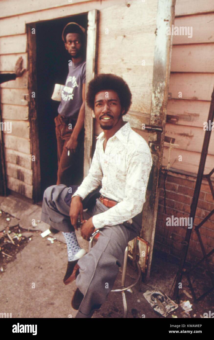 Ein Mann mit gemusterten Shirt und Socken belegt den Hocker außerhalb der Pool House, verweilende mit seinen Kumpels in die West Side von Chicago, Illinois, 1973. Mit freundlicher Genehmigung der nationalen Archive. Stockfoto