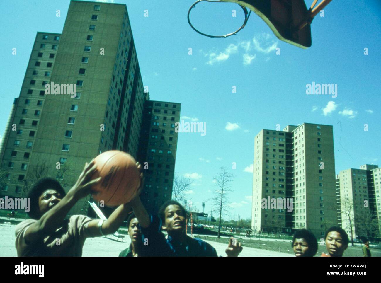 Teen boys für den Basketball während ein Pick-up-Spiel außerhalb Stateway Gärten" Hochhaus in der South Side von Chicago, Illinois, 1973 ringen. Mit freundlicher Genehmigung der nationalen Archive. Stockfoto