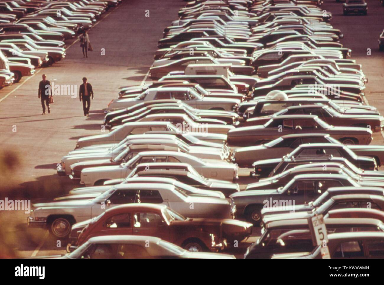 Männer zurück zu ihren Autos am Ende des Tages in die Monroe Street Parkplatz, wo Hunderte von Fahrzeugen in Chicago, Illinois, 1973 abgestellt werden. Mit freundlicher Genehmigung der nationalen Archive. Stockfoto