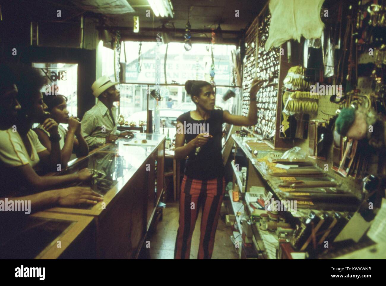 Eine Frau bedient Kunden in einem Baumarkt in der Schwarz-Besessen-business Hauptstadt der Vereinigten Staaten, der Südseite von Chicago, Illinois, 1973. Mit freundlicher Genehmigung der nationalen Archive. Stockfoto