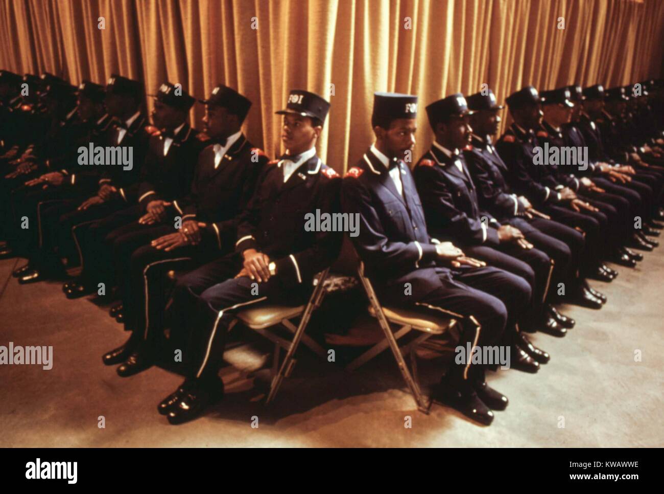 Die Frucht des Islam, einer Gruppe von Bodyguards für muslimische Führer Elijah Muhammad, sitzen, während er Tag die Botschaft seines jährlichen Retter in Chicago, Illinois, 1974 liefert. Bild mit freundlicher Genehmigung von John White/US National Archives. Mit freundlicher Genehmigung der nationalen Archive. Stockfoto