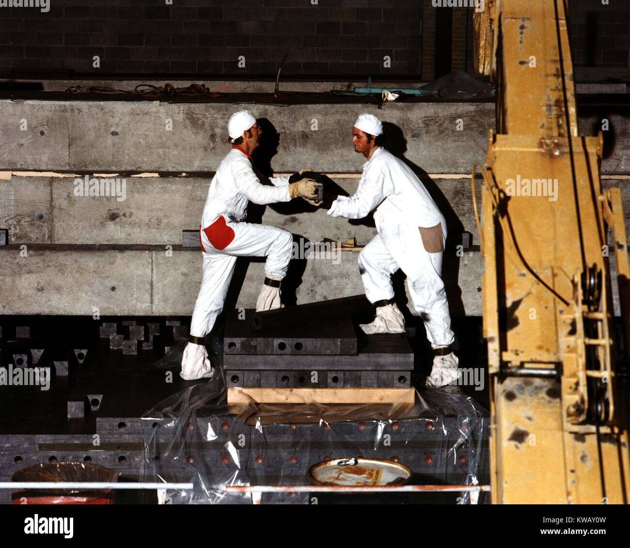 Arbeitskräfte, die den ganzen Körper Schutzausrüstung manuell die Graphit entladen Bausteine aus dem Kern des veralteten Hanford Test Reactor, mit freundlicher Genehmigung des US-Ministeriums für Energie, 2014. Stockfoto