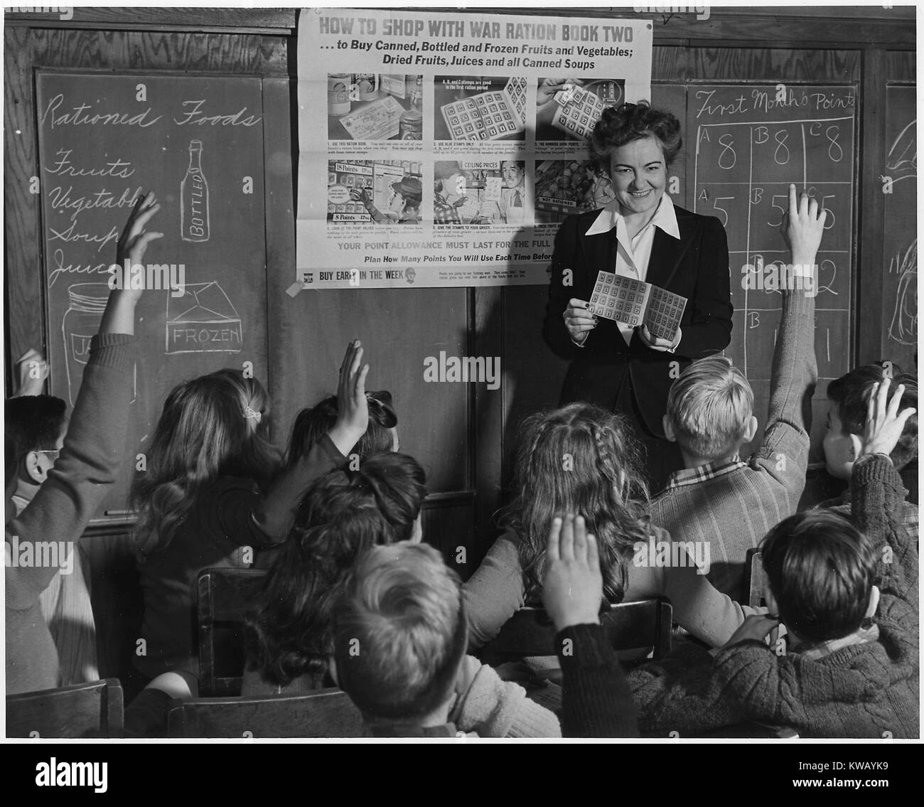 Die sechste Klasse Lehrerin zeigt Ihre Schüler auf, wie man Krieg Bezugsschein Zwei, Februar, 1943. Stockfoto