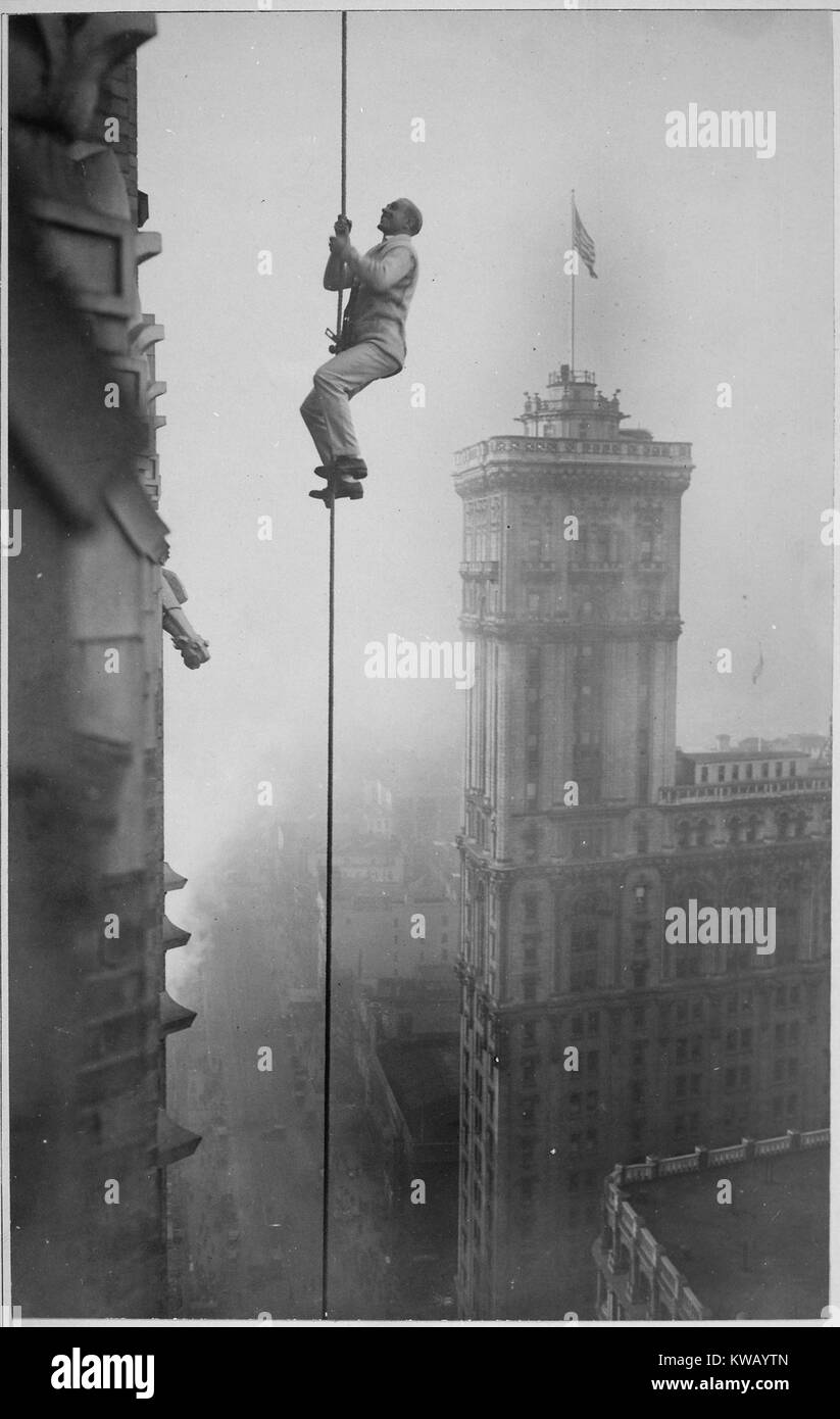 Halten auf einem dünnen Seil nach unten läuft von der Spitze eines Gebäudes in der Times Square, das "menschliche Eichhörnchen' führt einer seiner vielen empörend Stunts des Krieges Gelder in New York, New York, 1918 zu profitieren. Mit freundlicher Genehmigung der nationalen Archive. Stockfoto