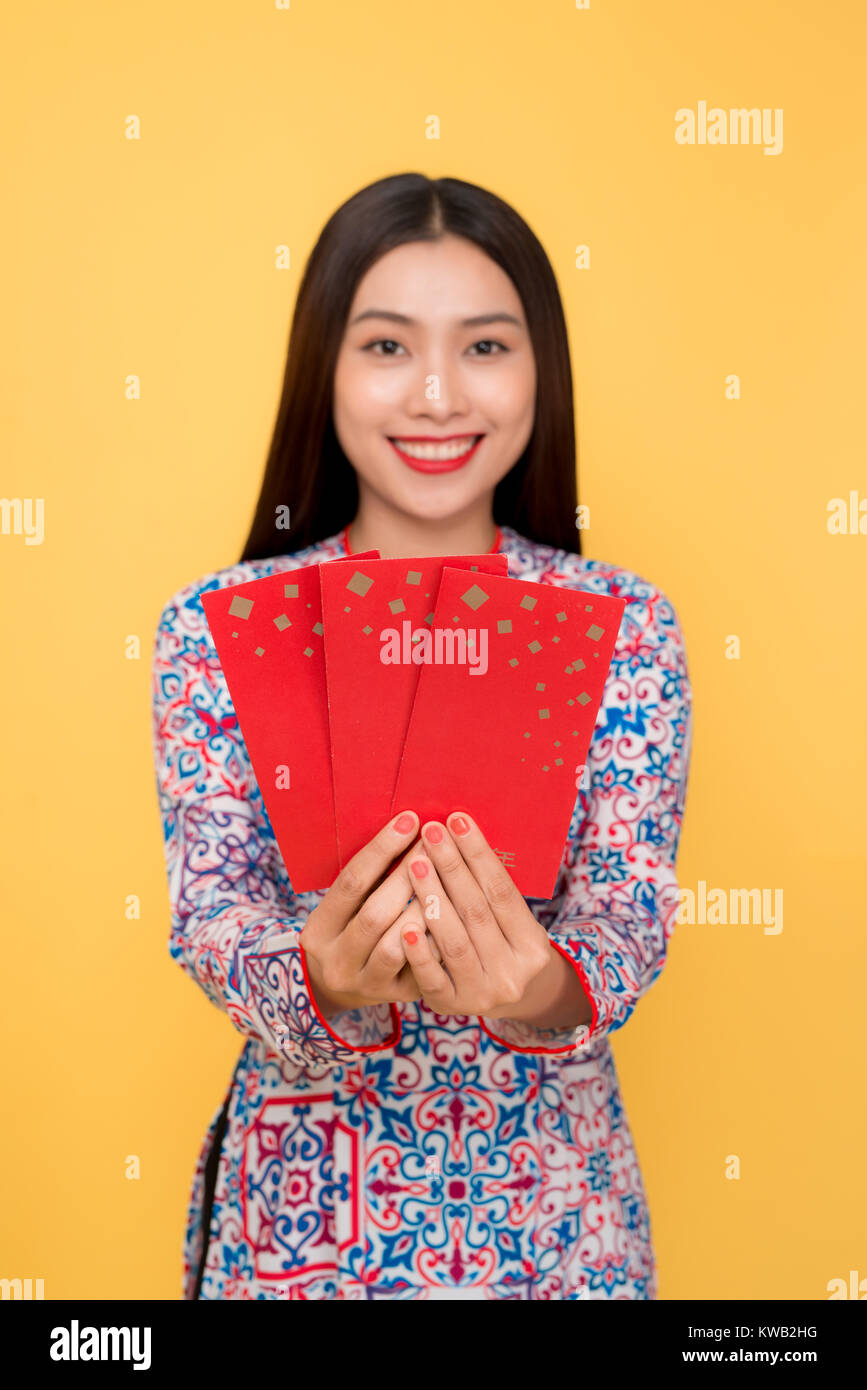 Schöne asiatische Frau auf traditionellen Festival kostüm Ao Dai Holding lucky Taschengeld Stockfoto