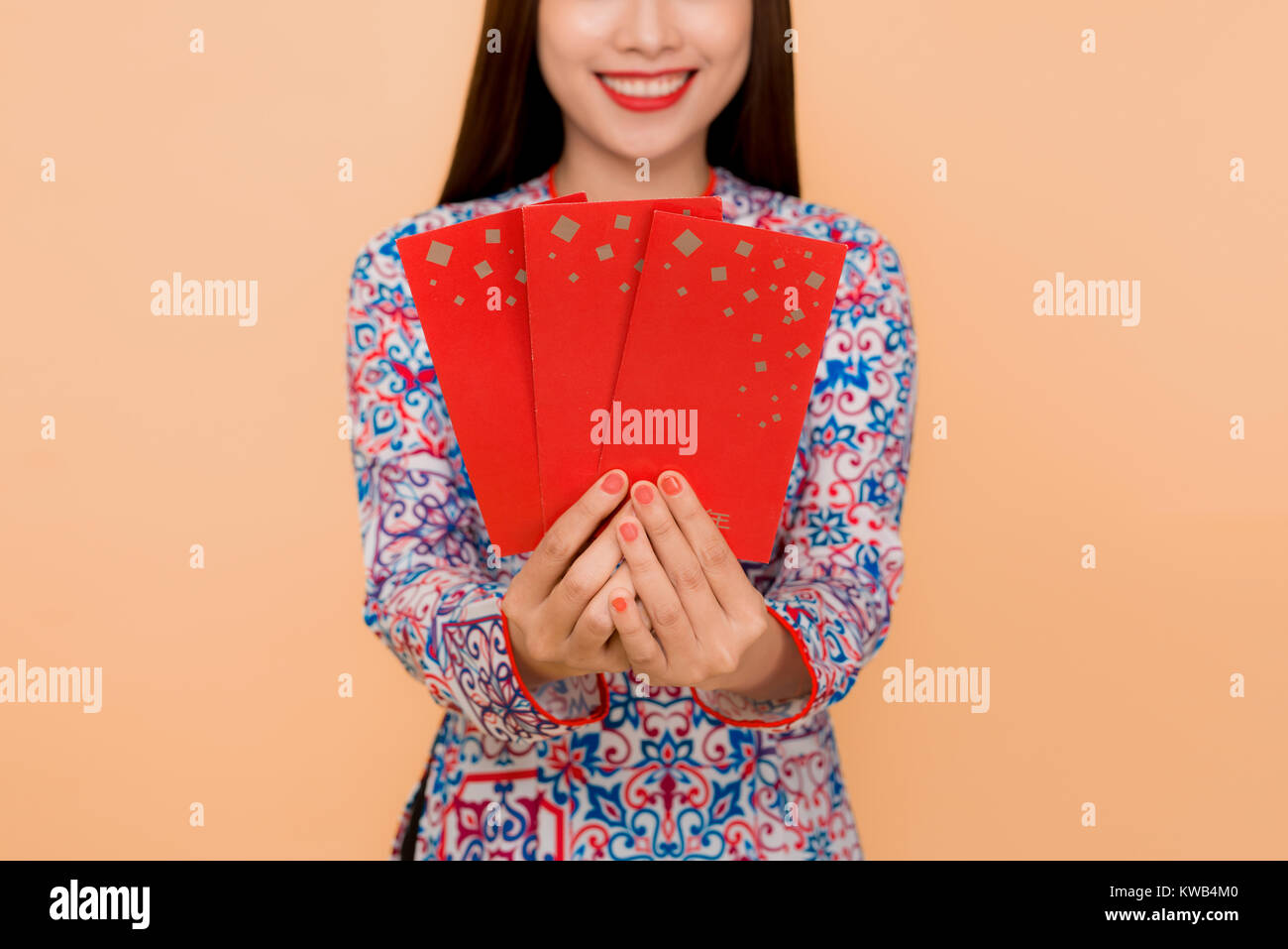 Schöne asiatische Frau auf traditionellen Festival kostüm Ao Dai Holding lucky Taschengeld Stockfoto