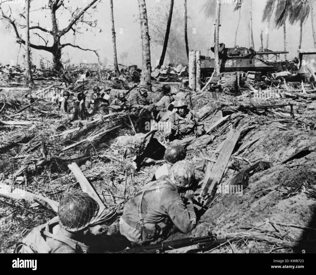 Us-Soldat hält seinen Vormarsch auf, während ein Tank blasts japanische Stellungen auf Kwajalein Island. Jan. 31 - Feb. 3, 1944. Marshall Inseln, Weltkrieg 2. (BSLOC 2014 10 104) Stockfoto