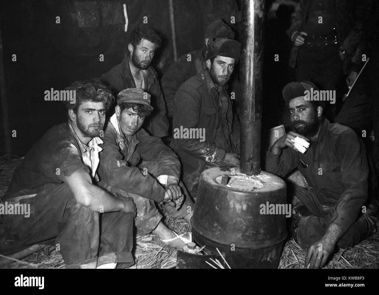 Freigegebene Amerikanische und australische Kriegsgefangene Erwärmung durch einen Herd. Sie sind in der 24 Abteilung Medizinische clearing Station nach den US-amerikanischen Linien durch die chinesischen Kommunisten, die zurückgegeben wird, 10. Februar 1951. Koreakrieg, 1950-1953. (BSLOC 2014 11 169) Stockfoto