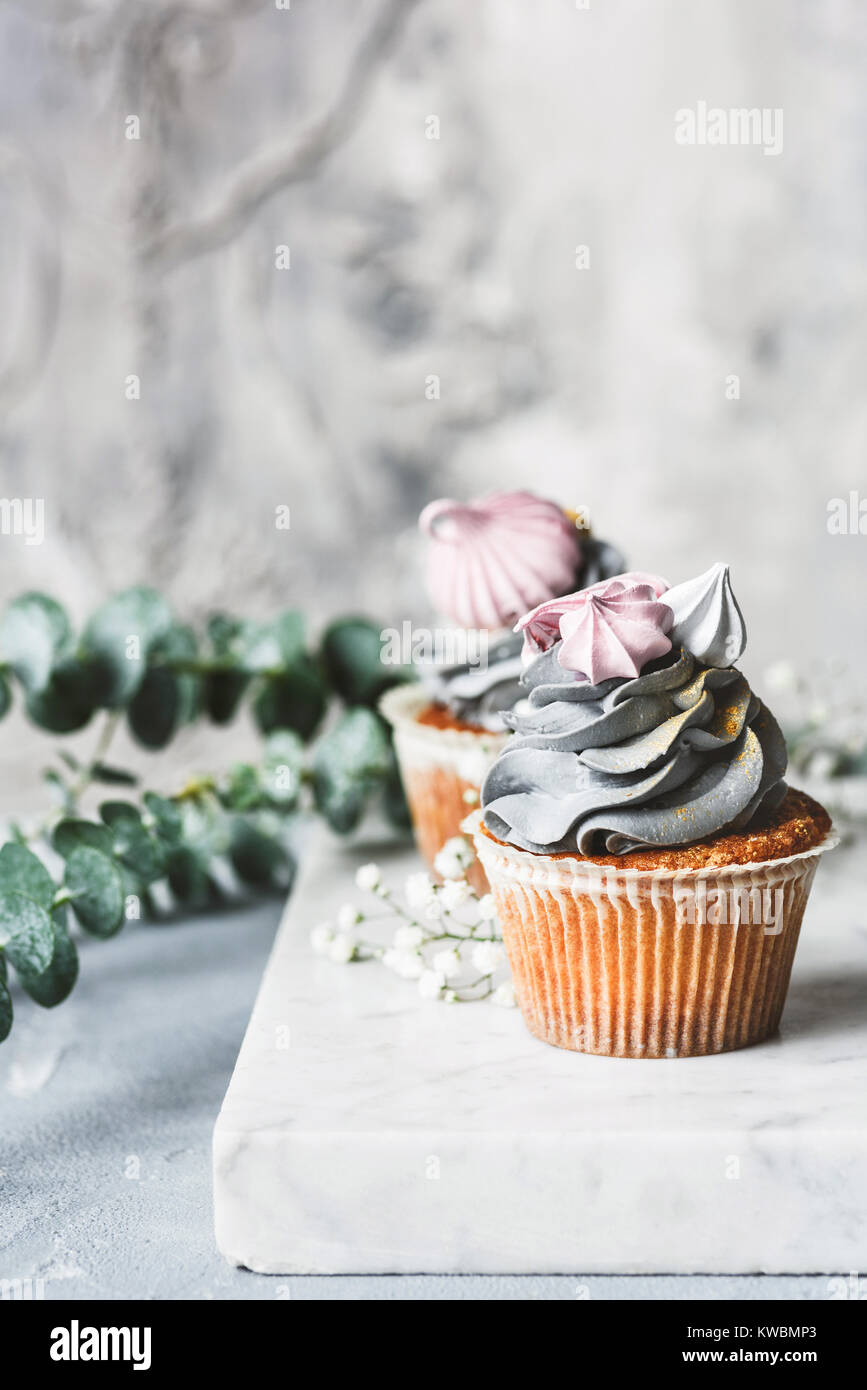 Leckere Cupcakes mit grauen buttercream und Baisers auf der Oberseite. Hochzeit, Valentinstag süße Speisen Konzept. Selektiver Fokus Stockfoto