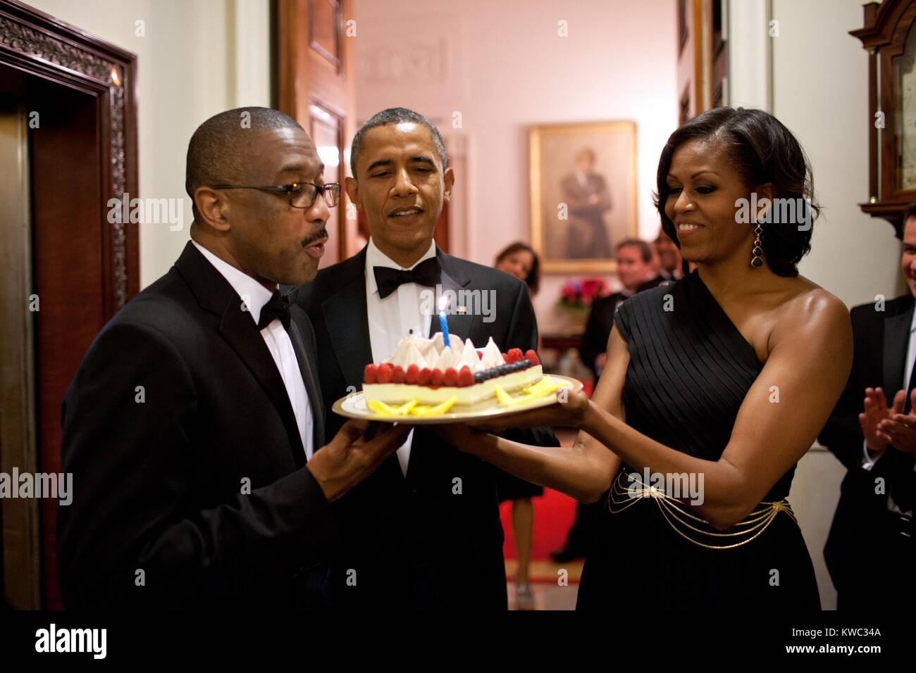 Präsident Barack Obama und Michelle Obama eine Geburtstagstorte Assistant Usher Reggie Dickson vorhanden. Juni 13, 2012. (BSLOC 2015 13 209) Stockfoto