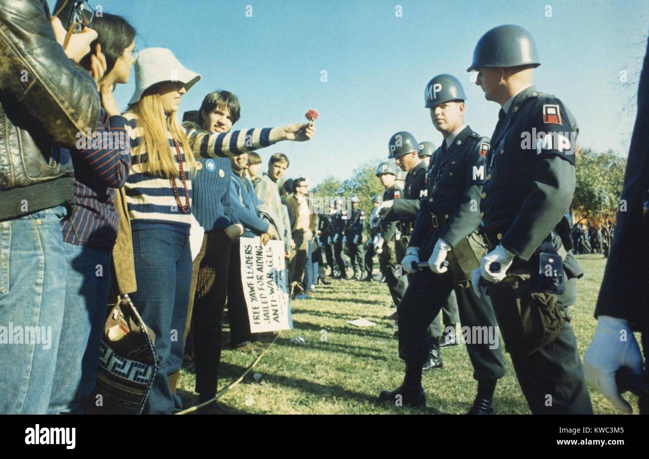 Weibliche Demonstrator bietet eine Blume zu militärischen Polizei während der 1967 Marsch auf das Pentagon. 50.000 Anti-Vietnam Krieg Demonstranten wurden von Abbie Hoffman led und marschierten von der Lincoln Memorial zum Pentagon am Okt. 21, 1967. (BSLOC 2015 14 137) Stockfoto