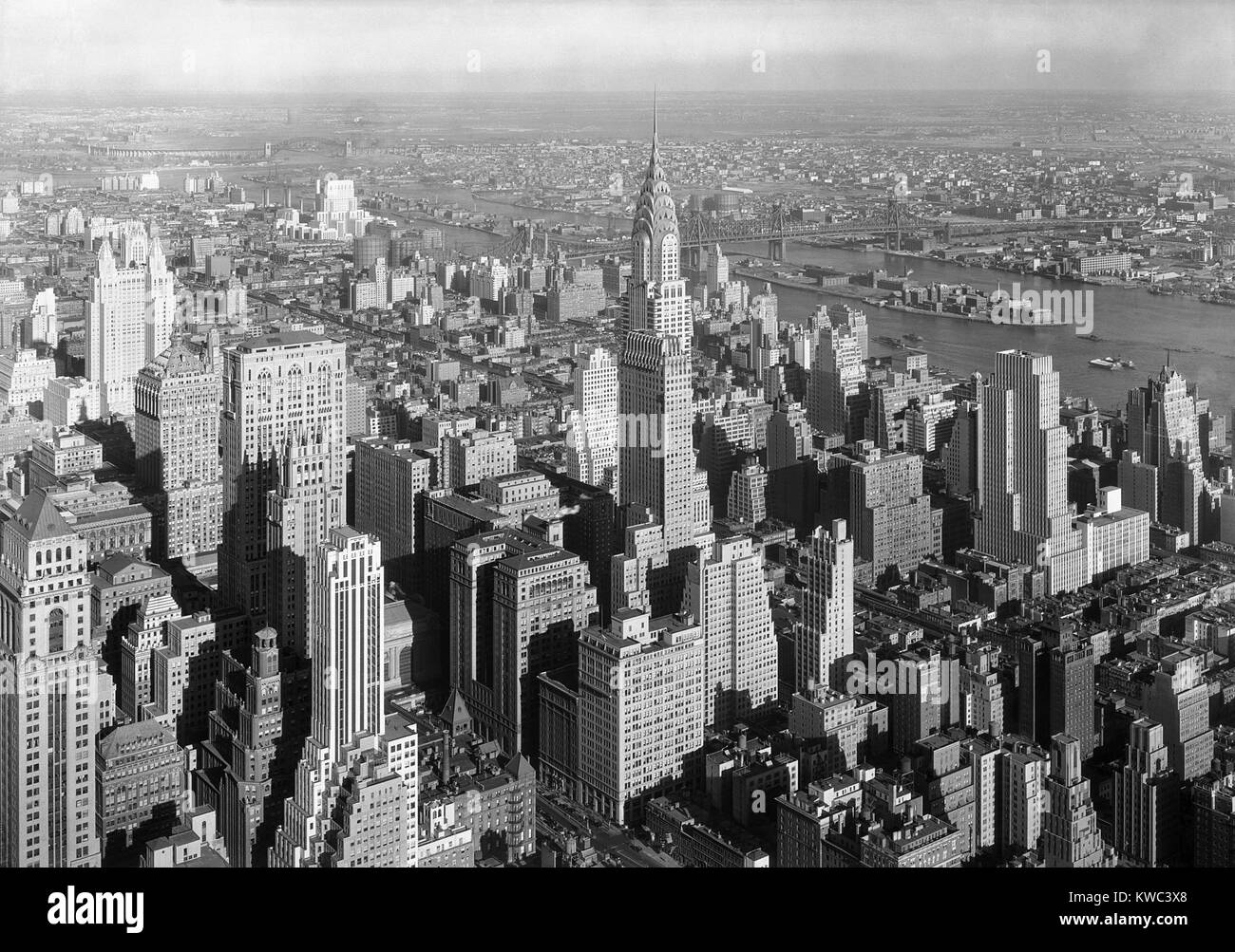 Nordost Blick aus der New York Empire State Building umfasst das Chrysler Building. Jan. 19, 1932. In der Mitte der Entfernung ist die Queensboro Brücke über den East River, und darüber hinaus ist der Stadtteil Queens und Long Island Sound. Foto von Samuel H. Gottscho. (BSLOC 2015 14 203) Stockfoto