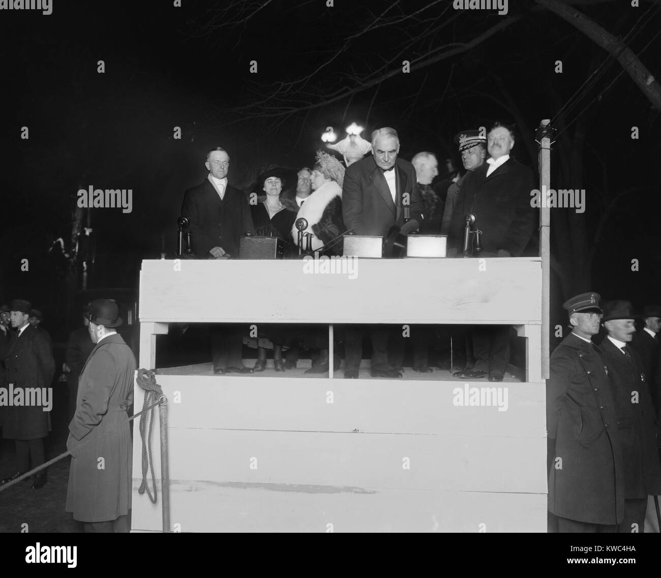 Präsident Warren Harding Drücken einer zeremoniellen Elektrische drücken. Mit ihm auf dem einfachen hölzernen Podium ist First Lady Florence Harding, Vice Präsident Calvin Coolidge und Gnade. Ca. 1921-22. (BSLOC 2015 15 41) Stockfoto